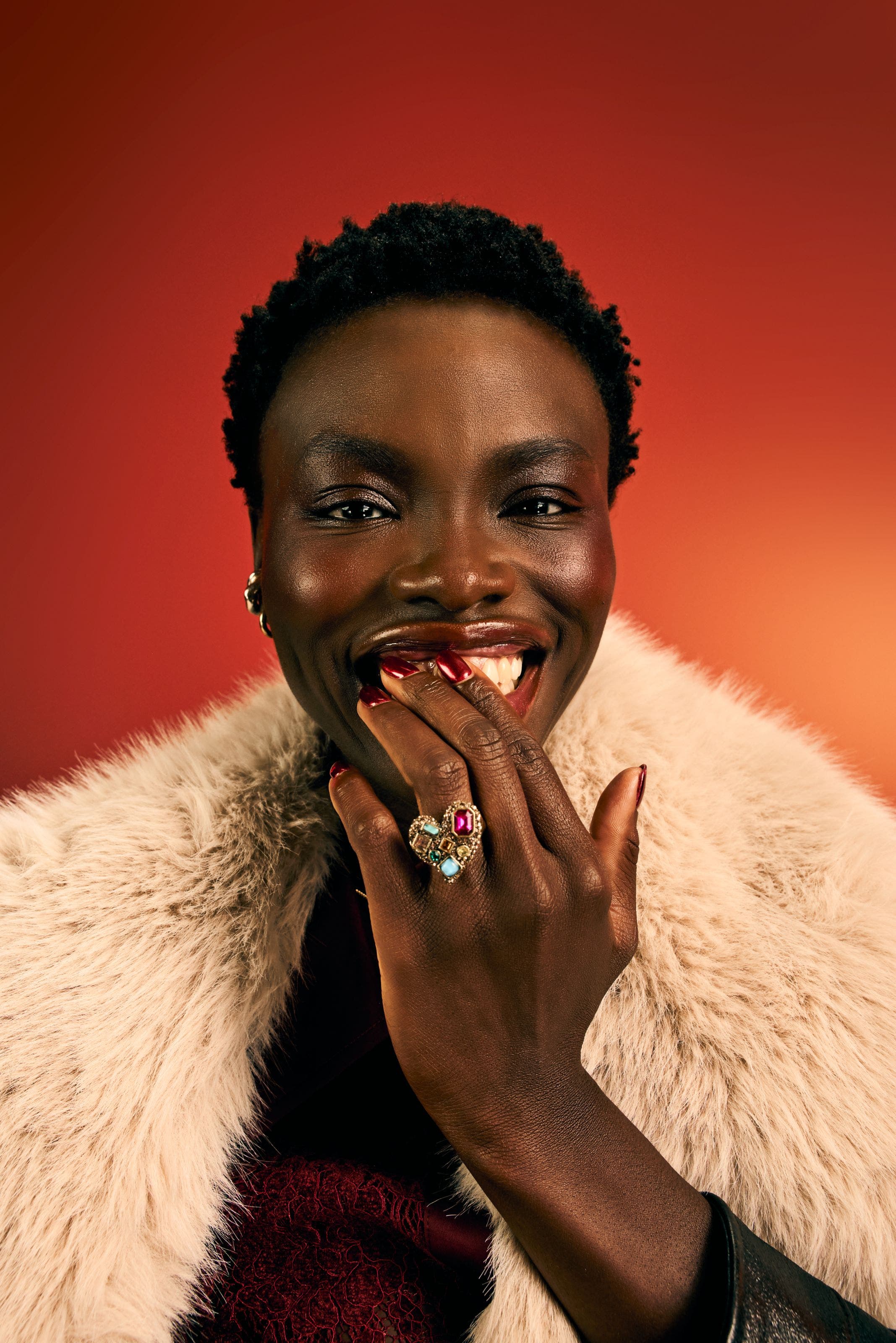 Woman in faux fur coat and cocktail ring.