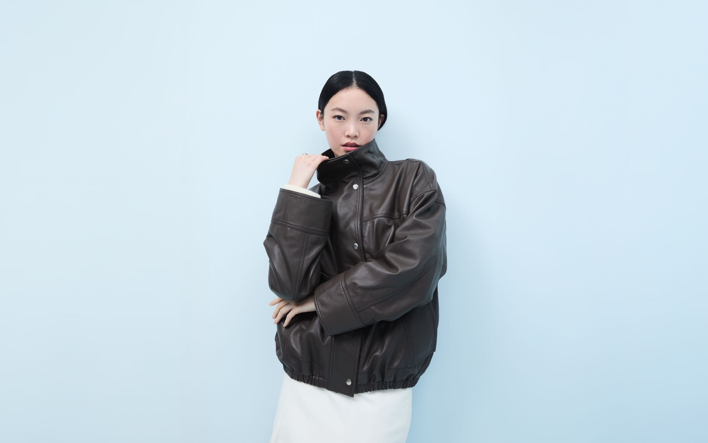 Woman wearing a brown leather jacket.