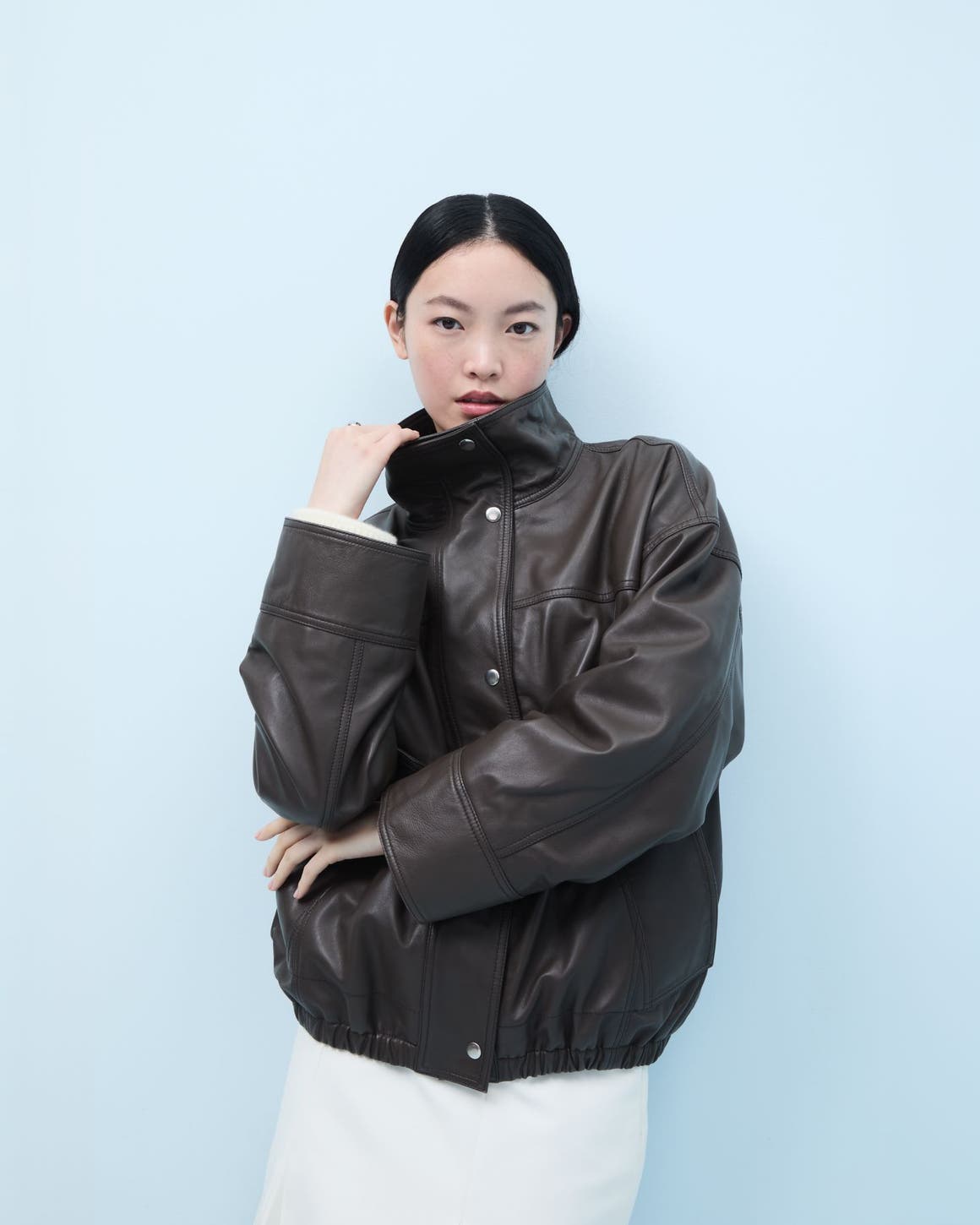Woman wearing a brown leather jacket.