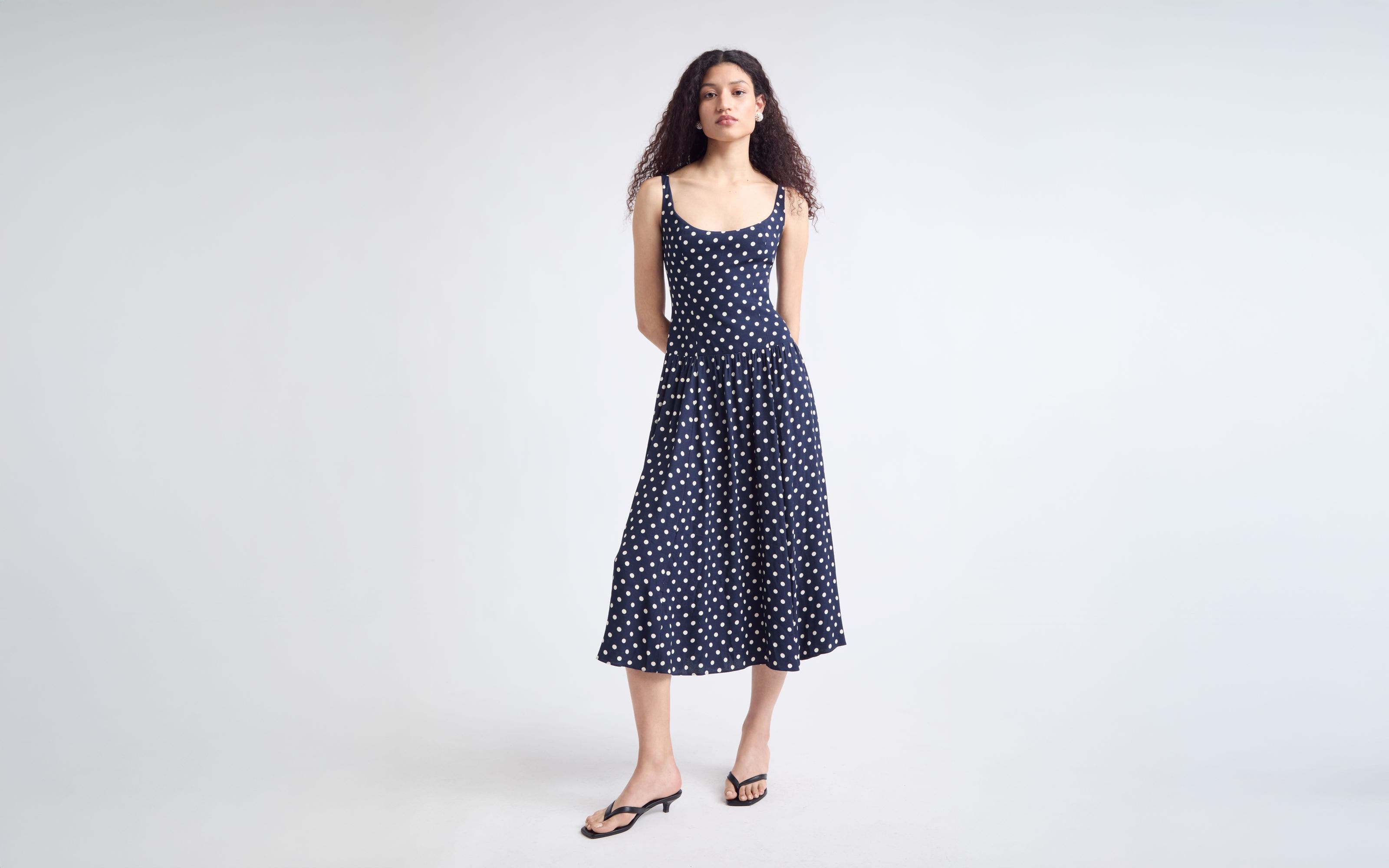 Woman wearing a matching white top and skirt with sunglasses.