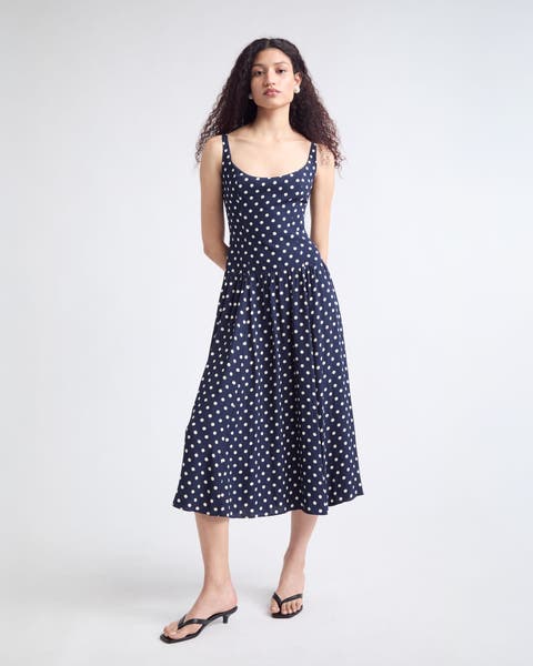 Woman wearing a matching white top and skirt with sunglasses.