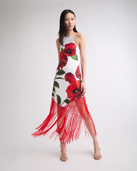 Woman wearing a floral print halter fringe hem midi dress.