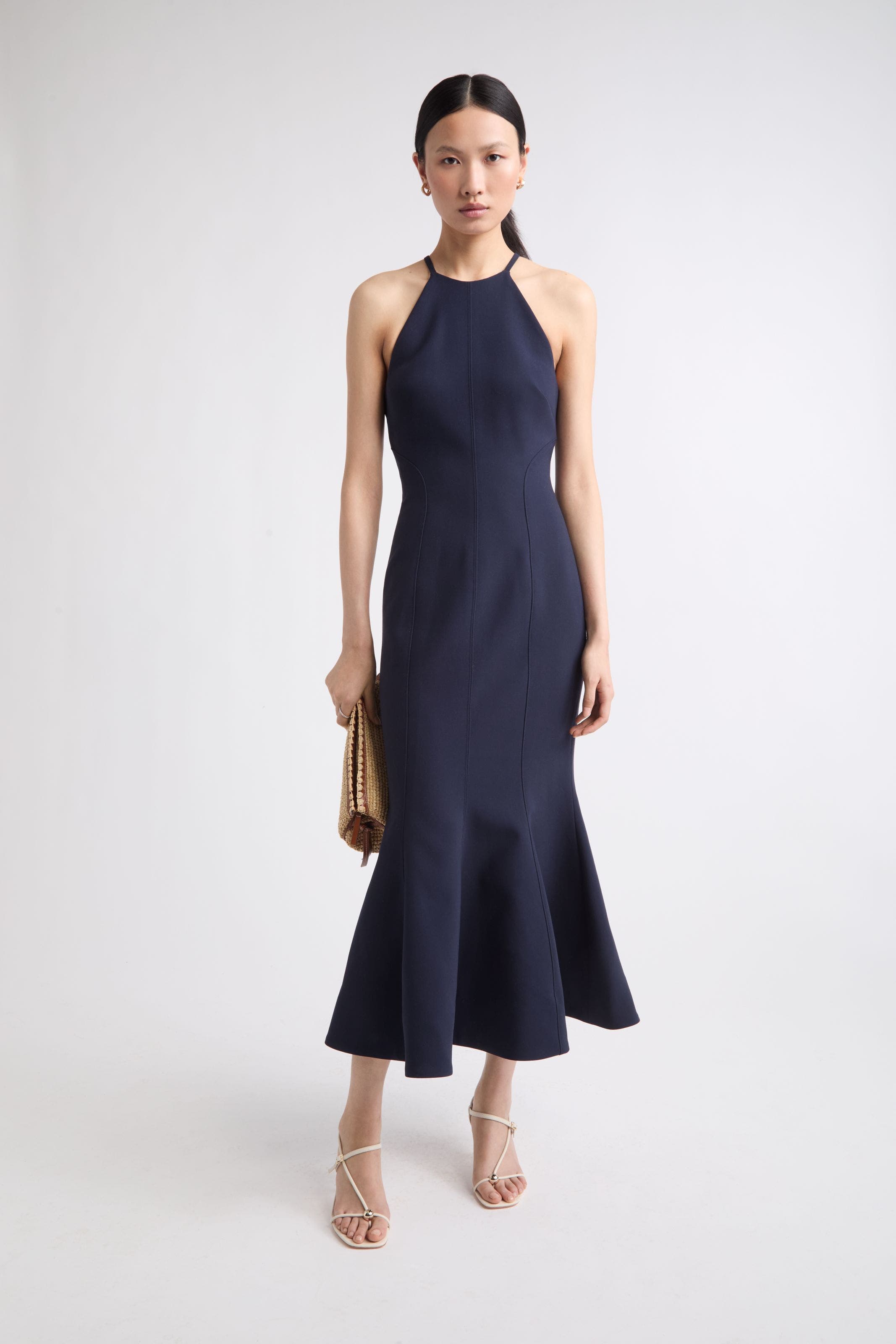 Woman wearing navy midi halter dress.