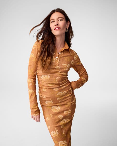 A woman wearing a long-sleeve floral maxi dress.