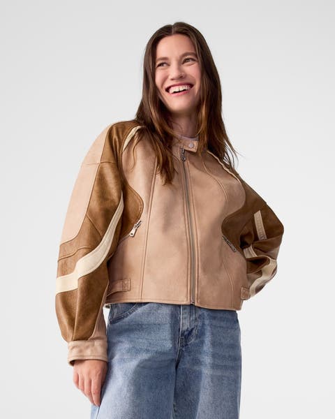 A woman wearing a patterned jacket and jeans.