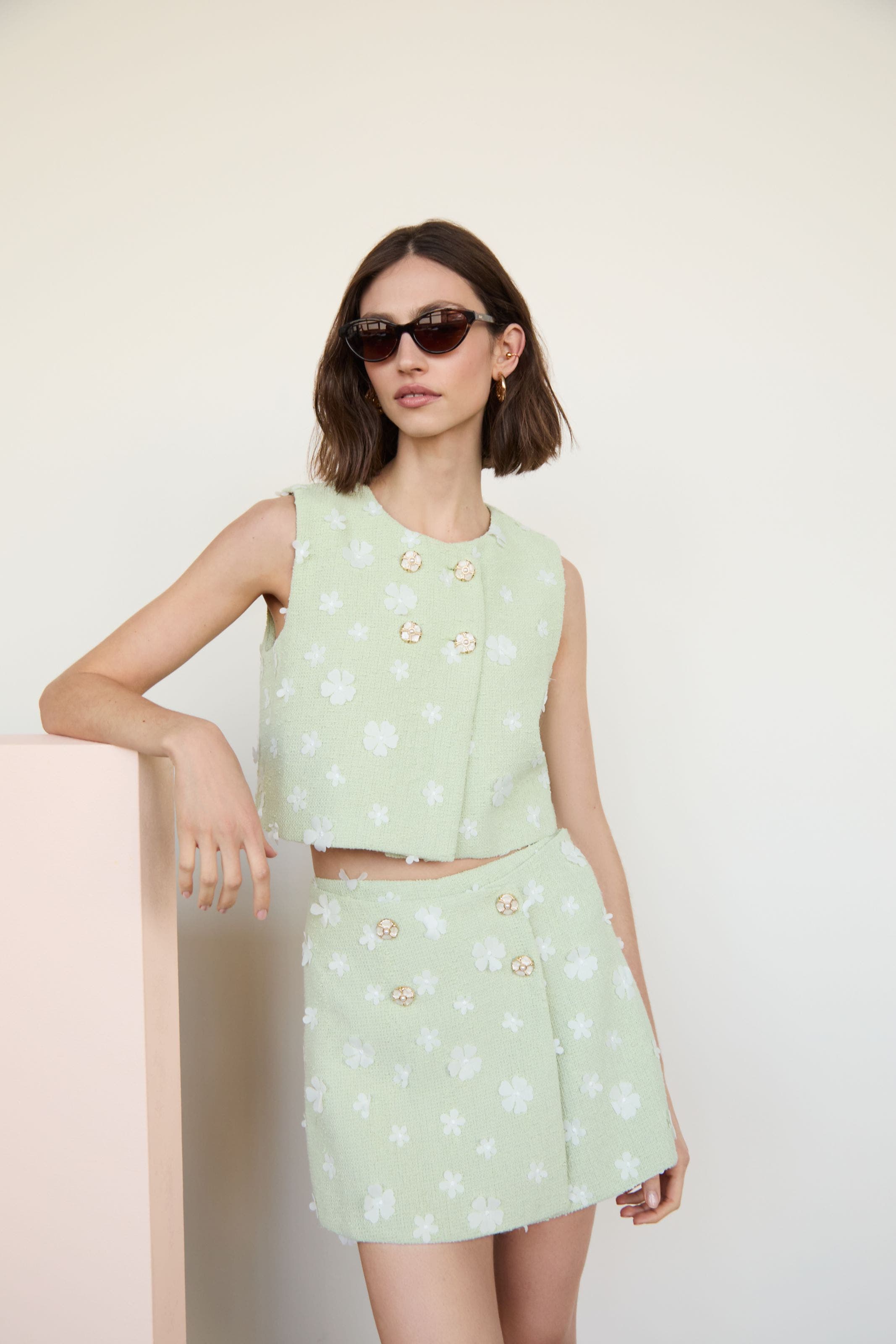 A woman wearing a pair of brown sunglasses.