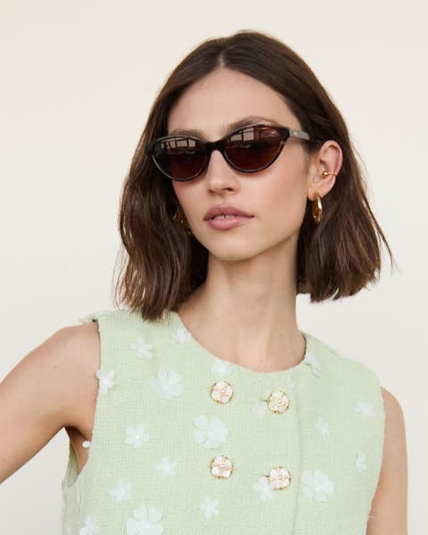 A woman wearing a pair of brown sunglasses.