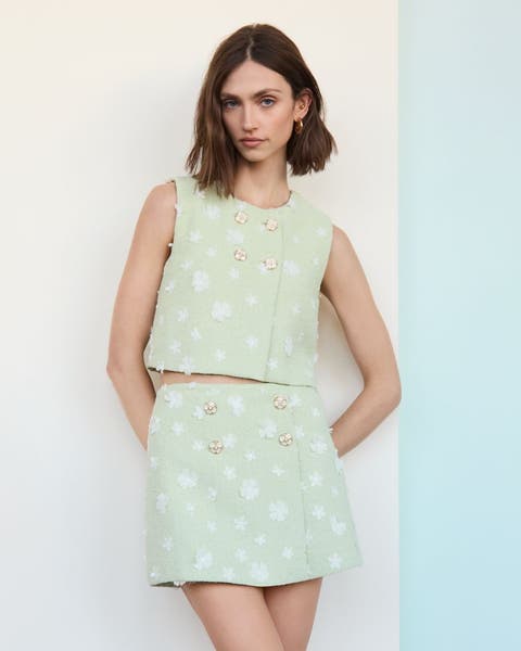 A woman wearing a matching mint green polka dot skirt and blouse.