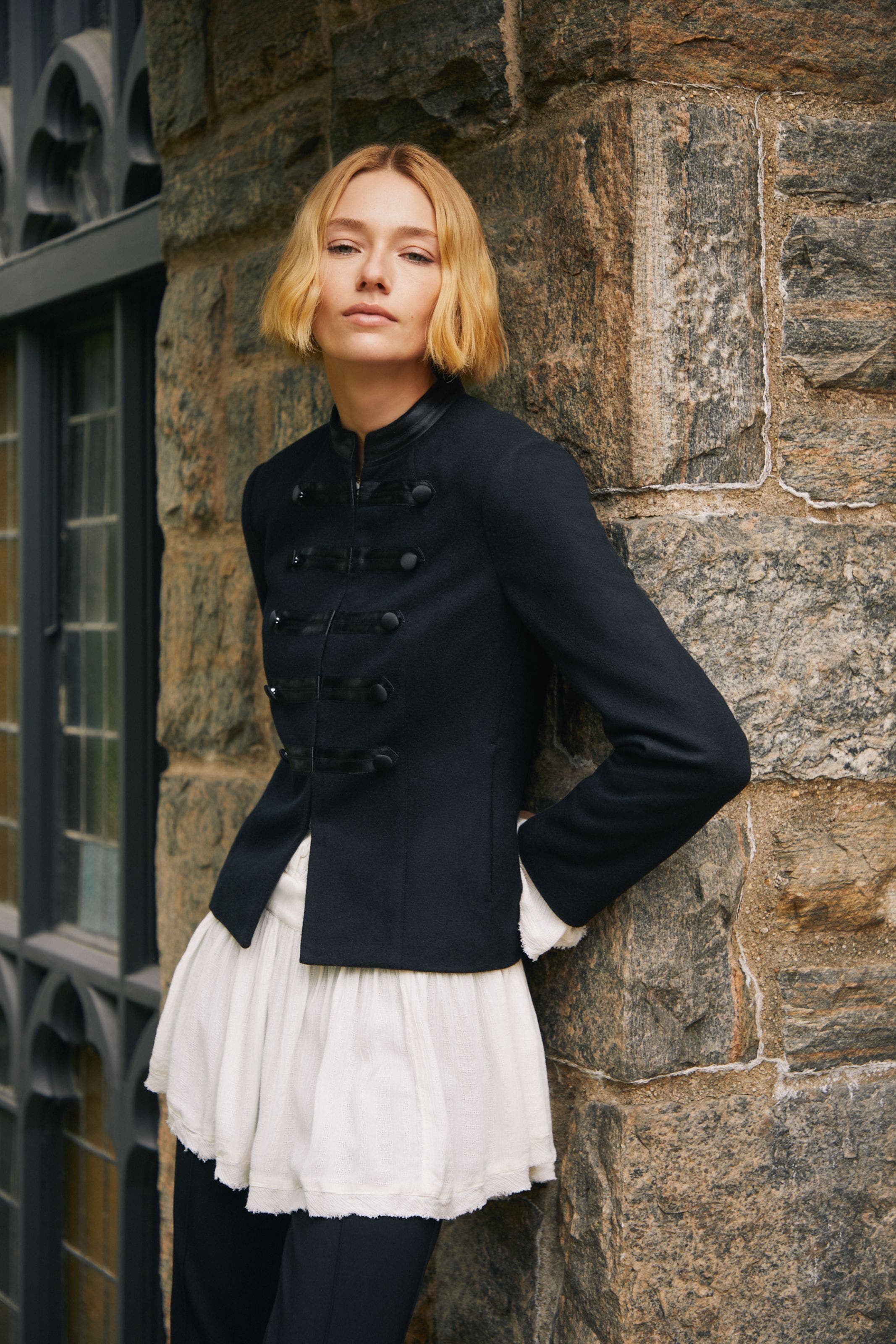 A woman wearing a blazer and ruffle blouse.