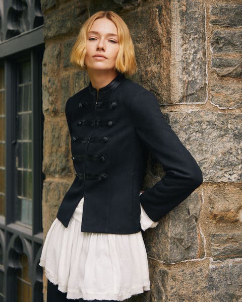 A woman wearing a blazer and ruffle blouse.