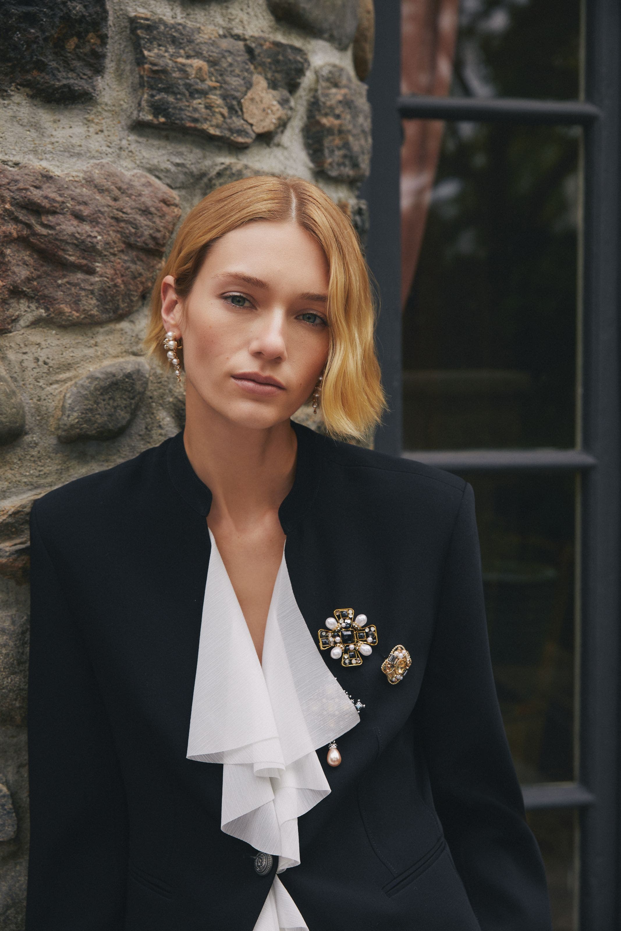 A woman wearing several brooches. 
