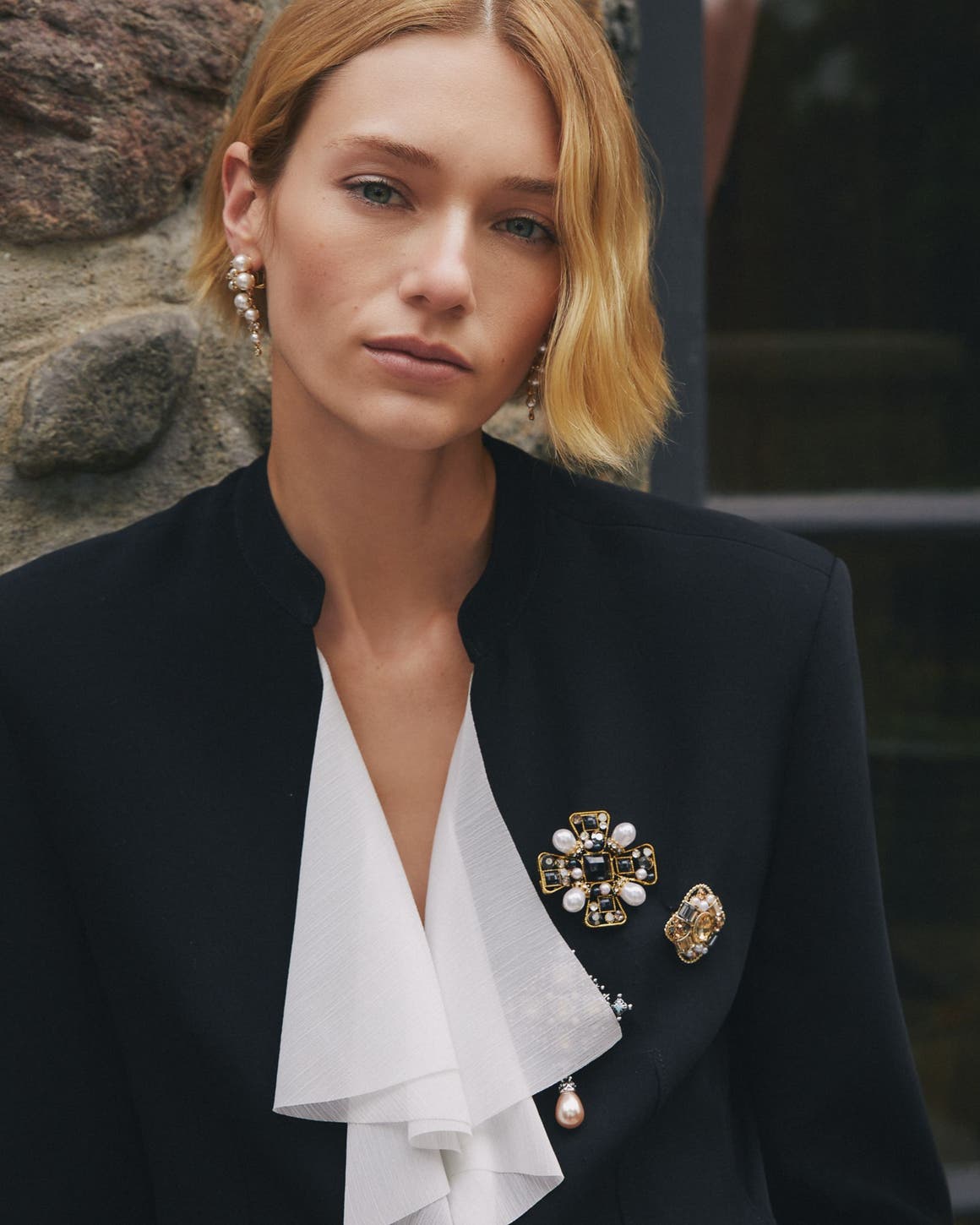 A woman wearing several brooches.