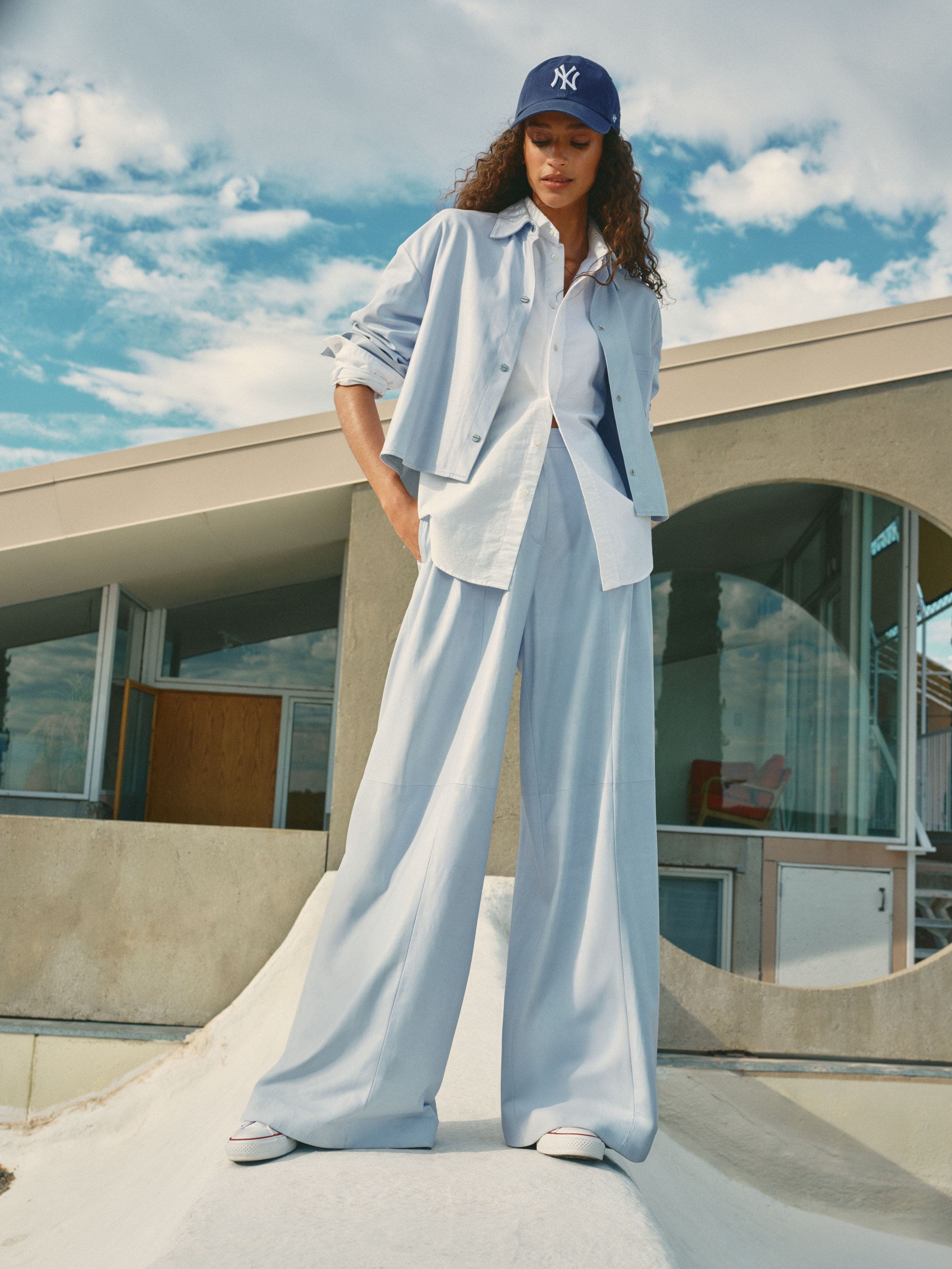 A woman wearing layered button-up shirts.