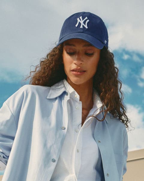 A woman wearing a blue baseball hat.