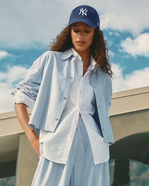 A woman wearing layered button-up shirts.