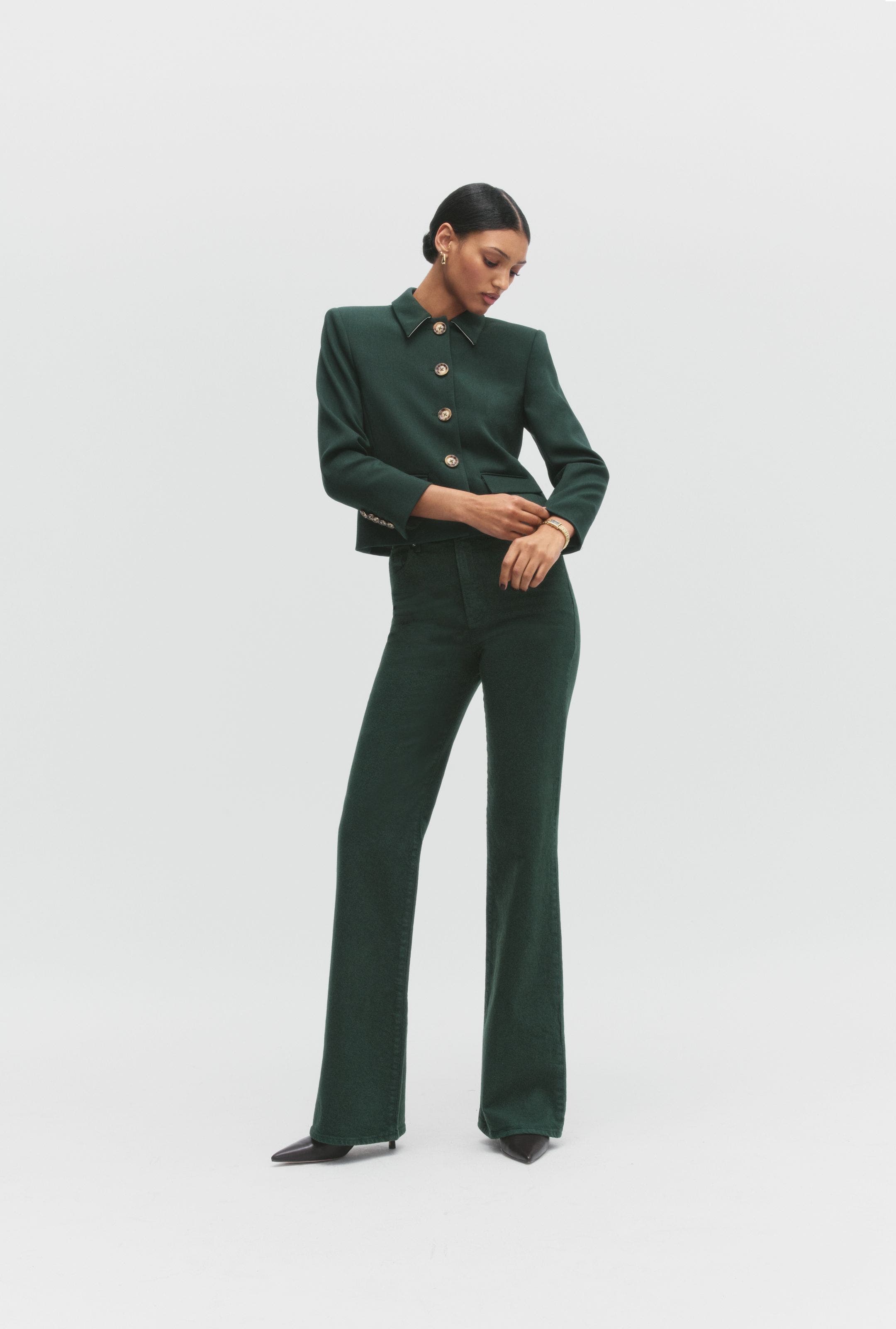 A woman wearing a green jacket and pants.