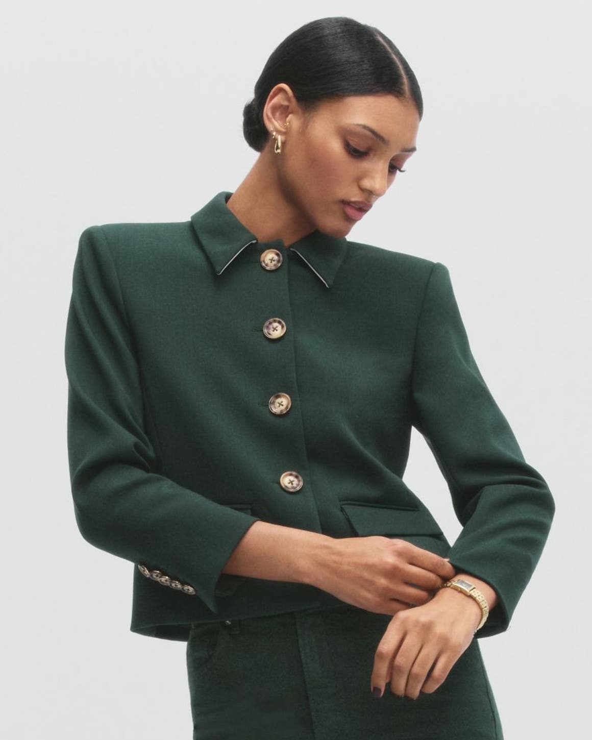 A woman wearing a green jacket and pants.