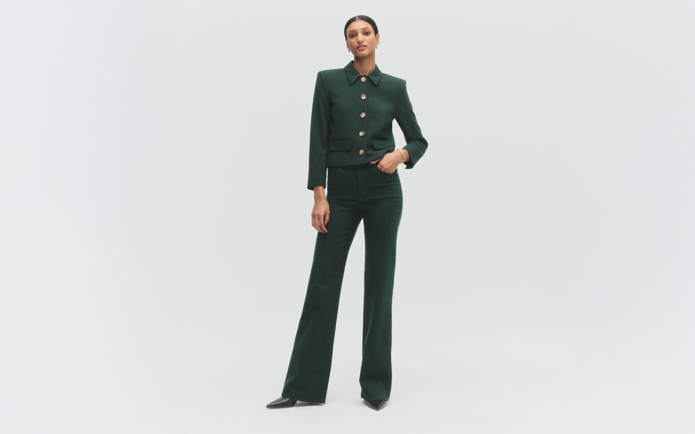 A woman wearing a green jacket and matching pants.