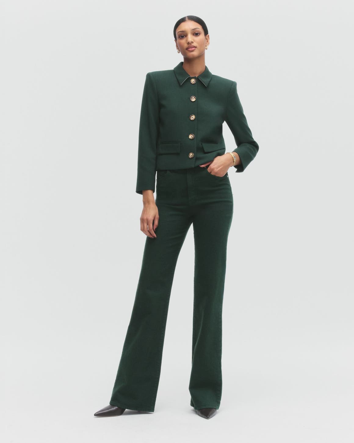 A woman wearing a green jacket and matching pants.