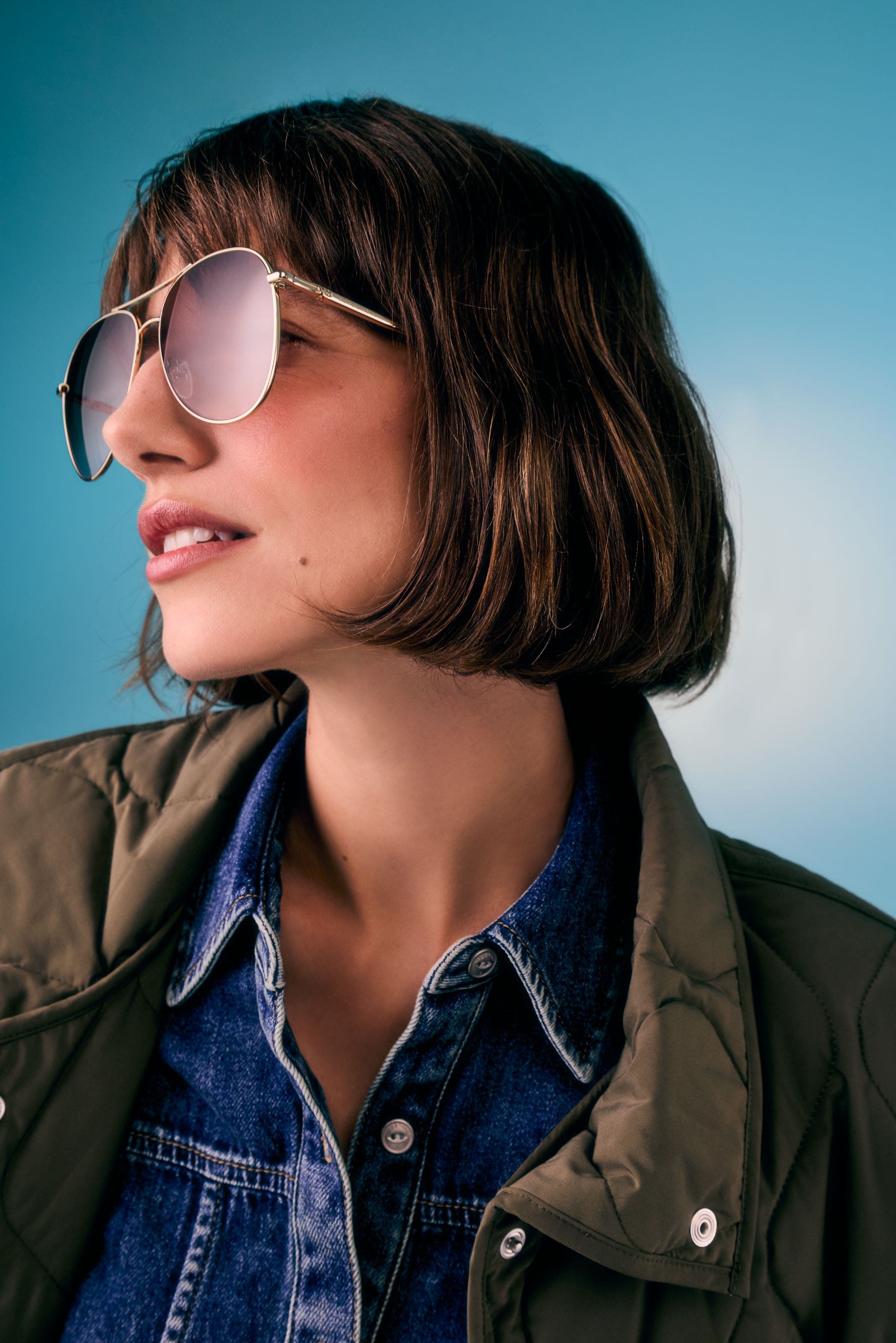 Woman wearing oversized gold aviator sunglasses.