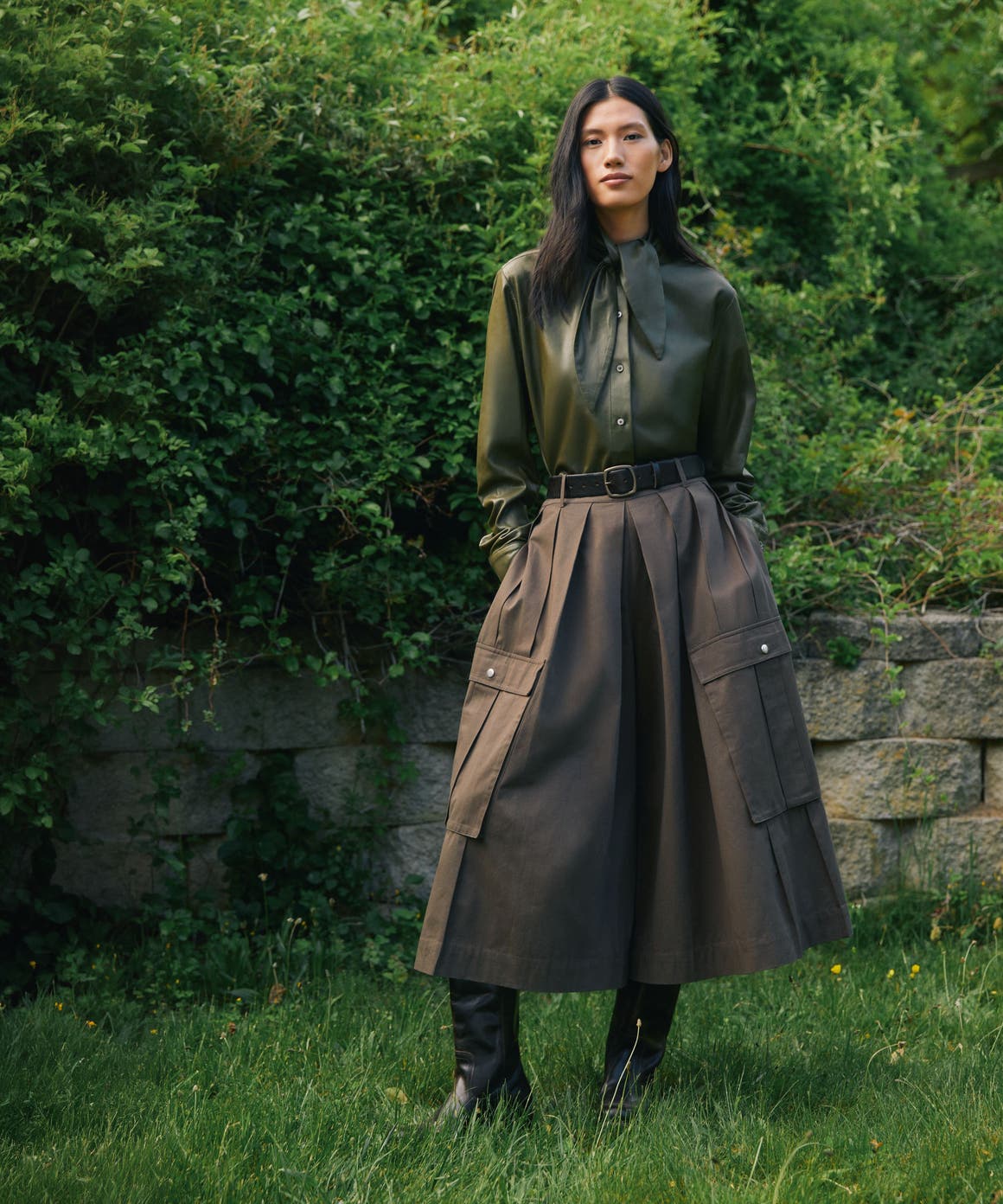 A woman wearing a button-up shirt and skirt.