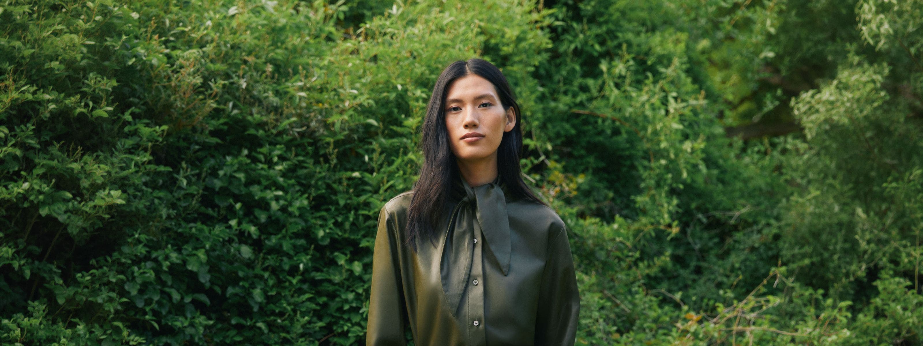 A woman wearing a button-up shirt and skirt.