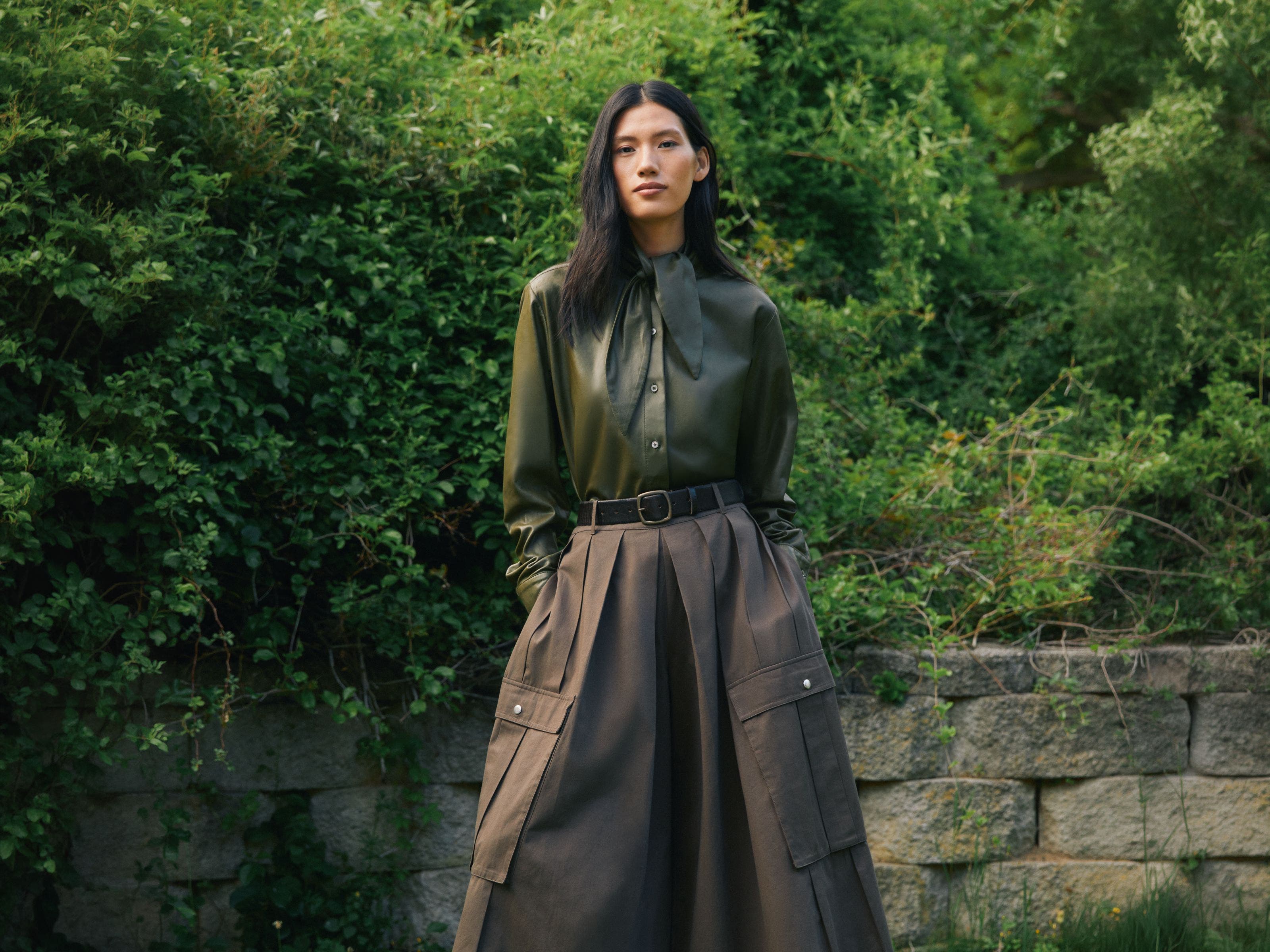 A woman wearing a button-up shirt and skirt.