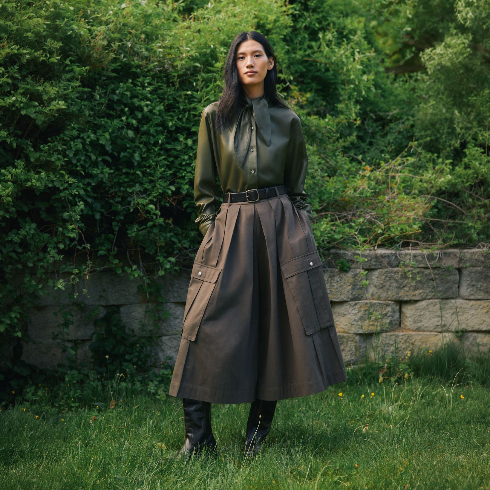 A woman wearing a button-up shirt and skirt.