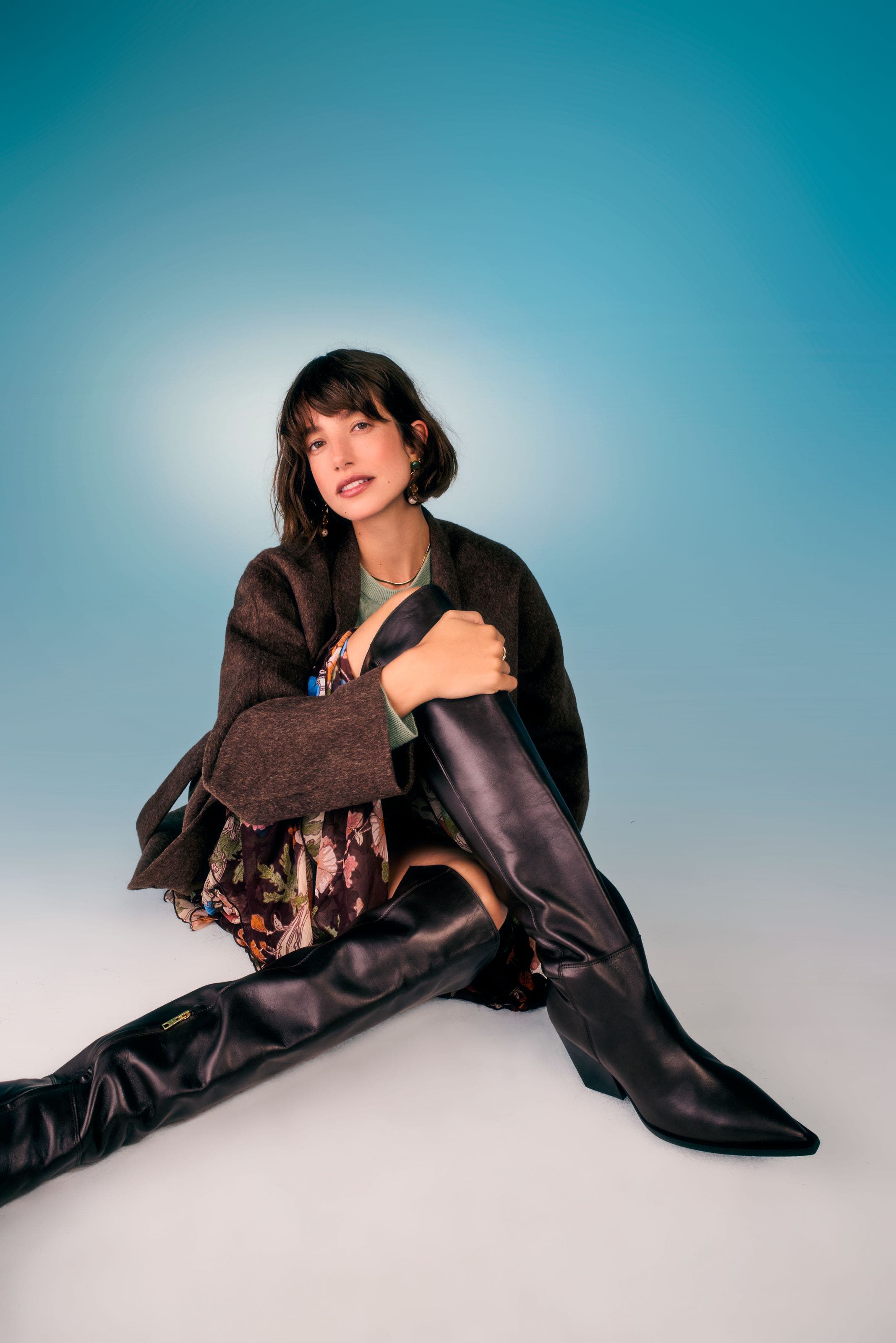 Woman wearing black pointed-toe knee‑high boots.