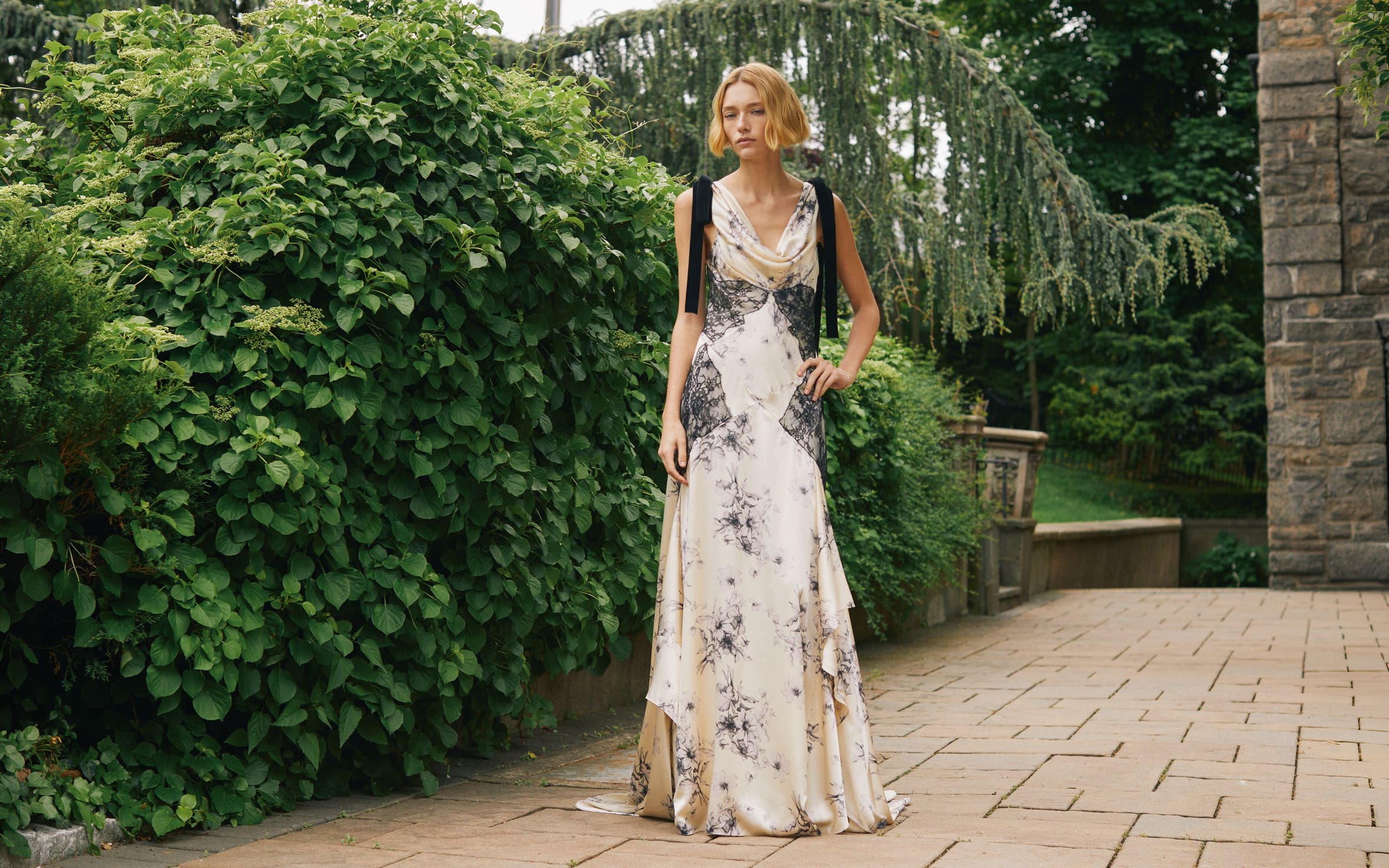 A woman wearing a white dress with black lace and florals.