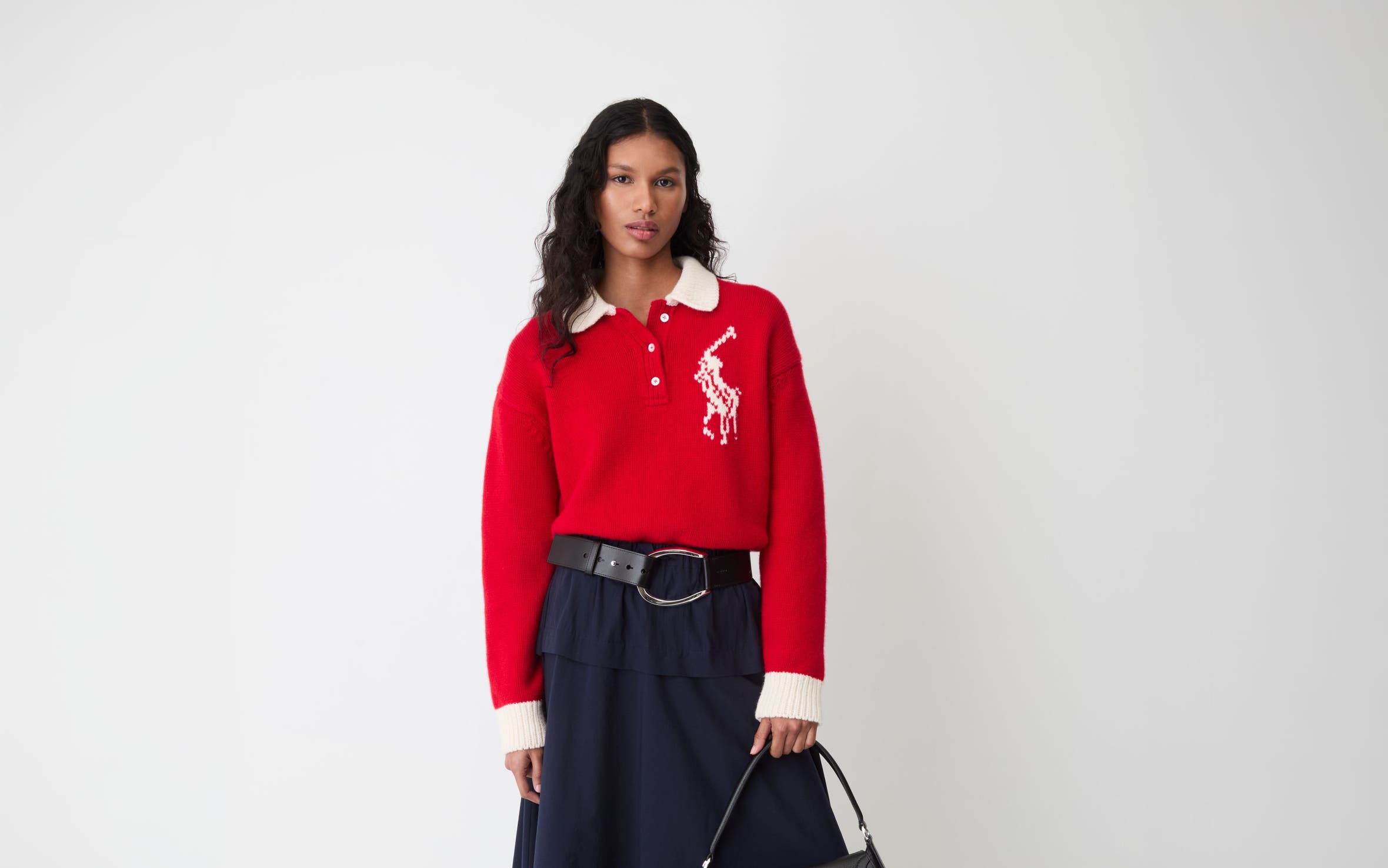 A woman wearing a red Polo Ralph Lauren sweater and a black maxi skirt.