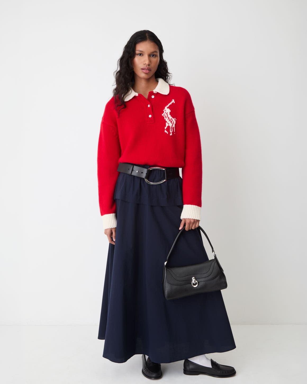 A woman wearing a red Polo Ralph Lauren sweater and a black maxi skirt.