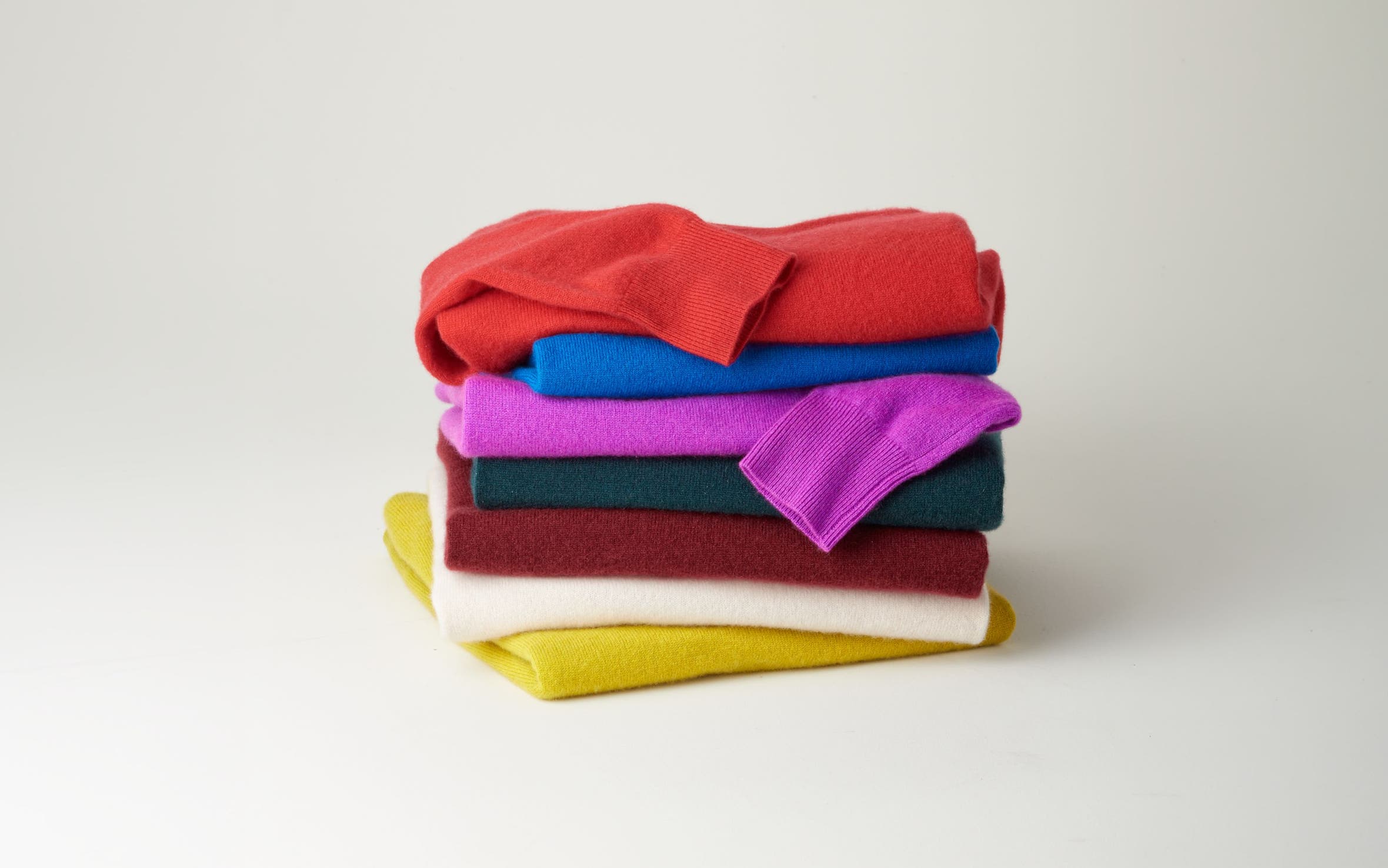 Two women, a man and a girl wearing cashmere sweaters and accessories.