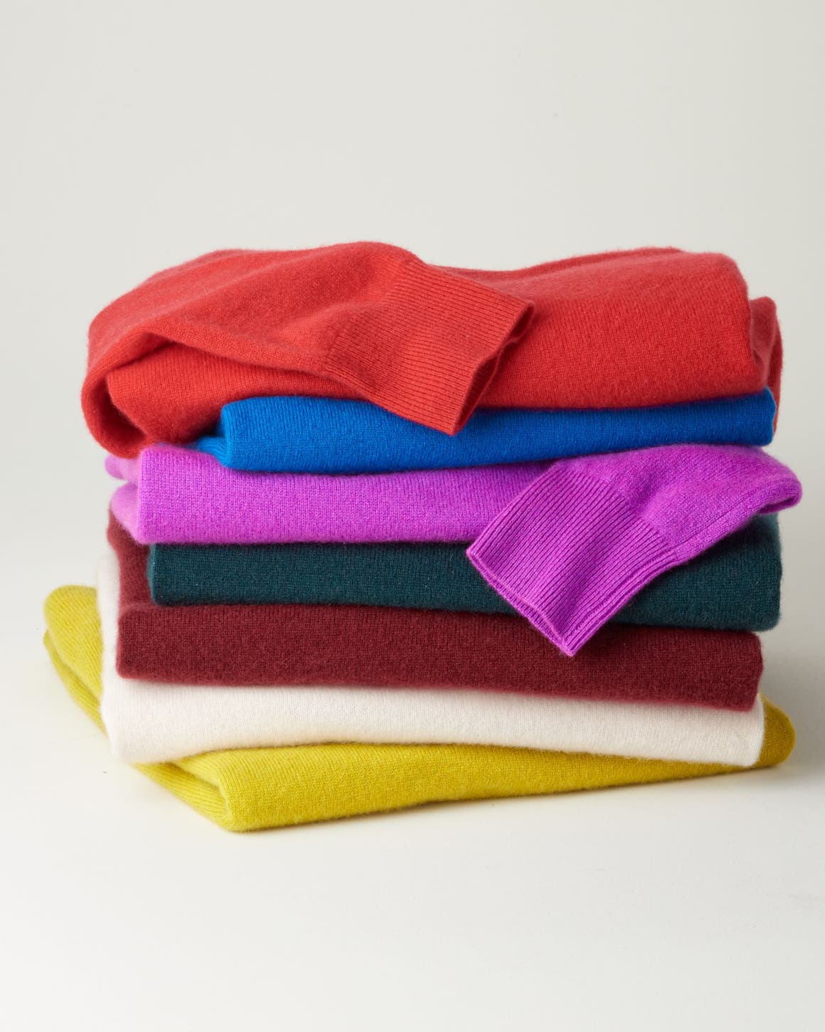 Two women, a man and a girl wearing cashmere sweaters and accessories.