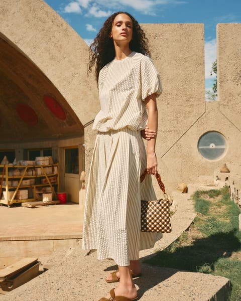 Woman wearing a breezy seersucker top and matching skirt.