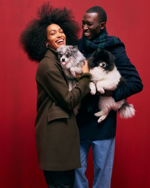 A man and woman holding small dogs.