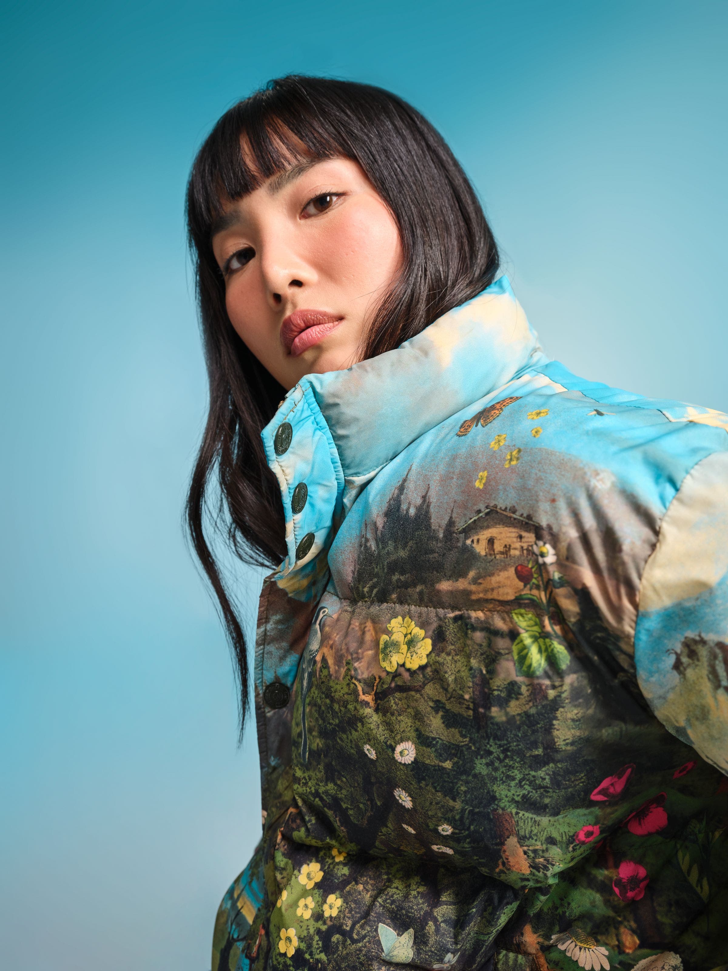 Woman wearing a colorful, printed puffer jacket.