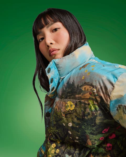 Woman in a landscape-print puffer jacket with a stand collar.