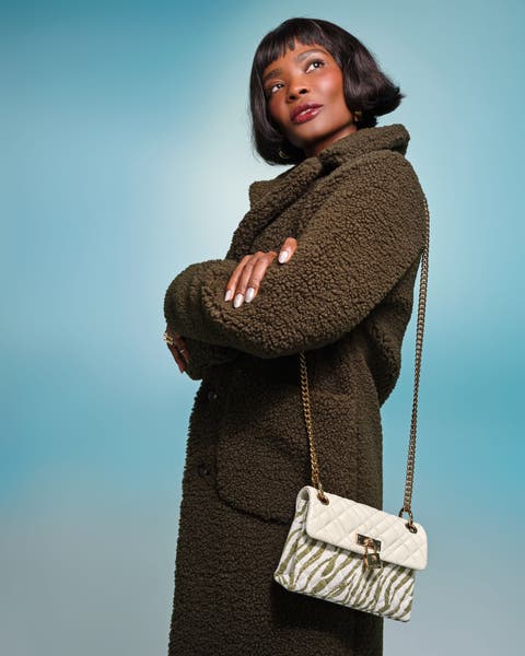 Model wearing a dark olive teddy coat with a zebra print crossbody bag.