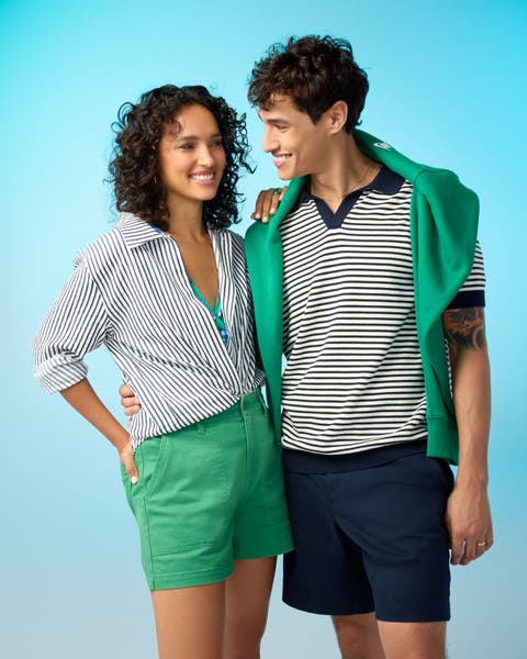 A man and a woman wearing shorts with striped shirts.