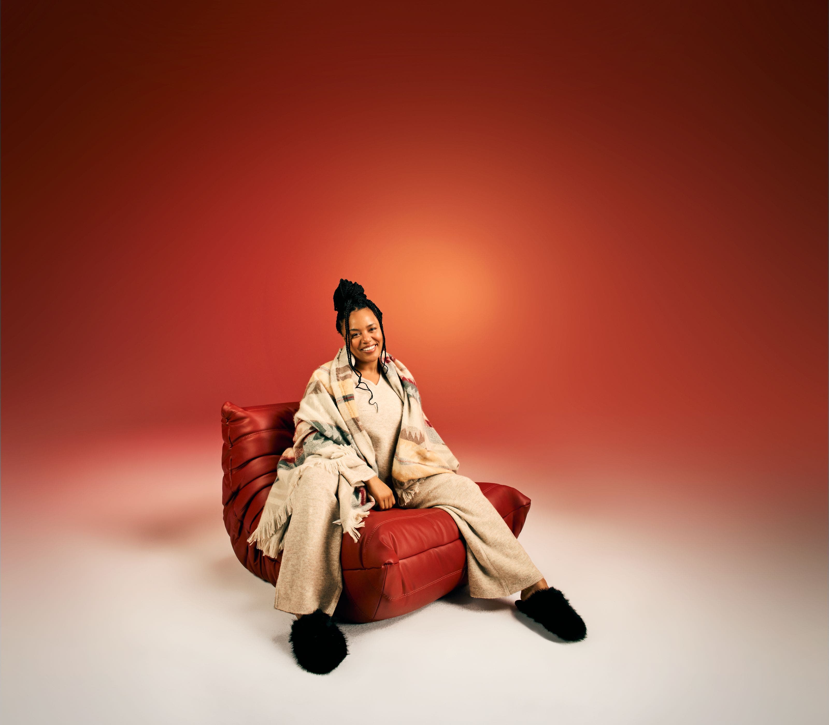 A woman relaxes on a couch with a Pendleton blanket.