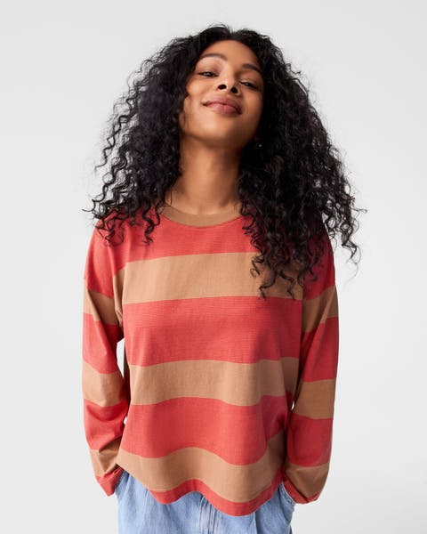 A woman wearing a striped long-sleeve top with jeans.