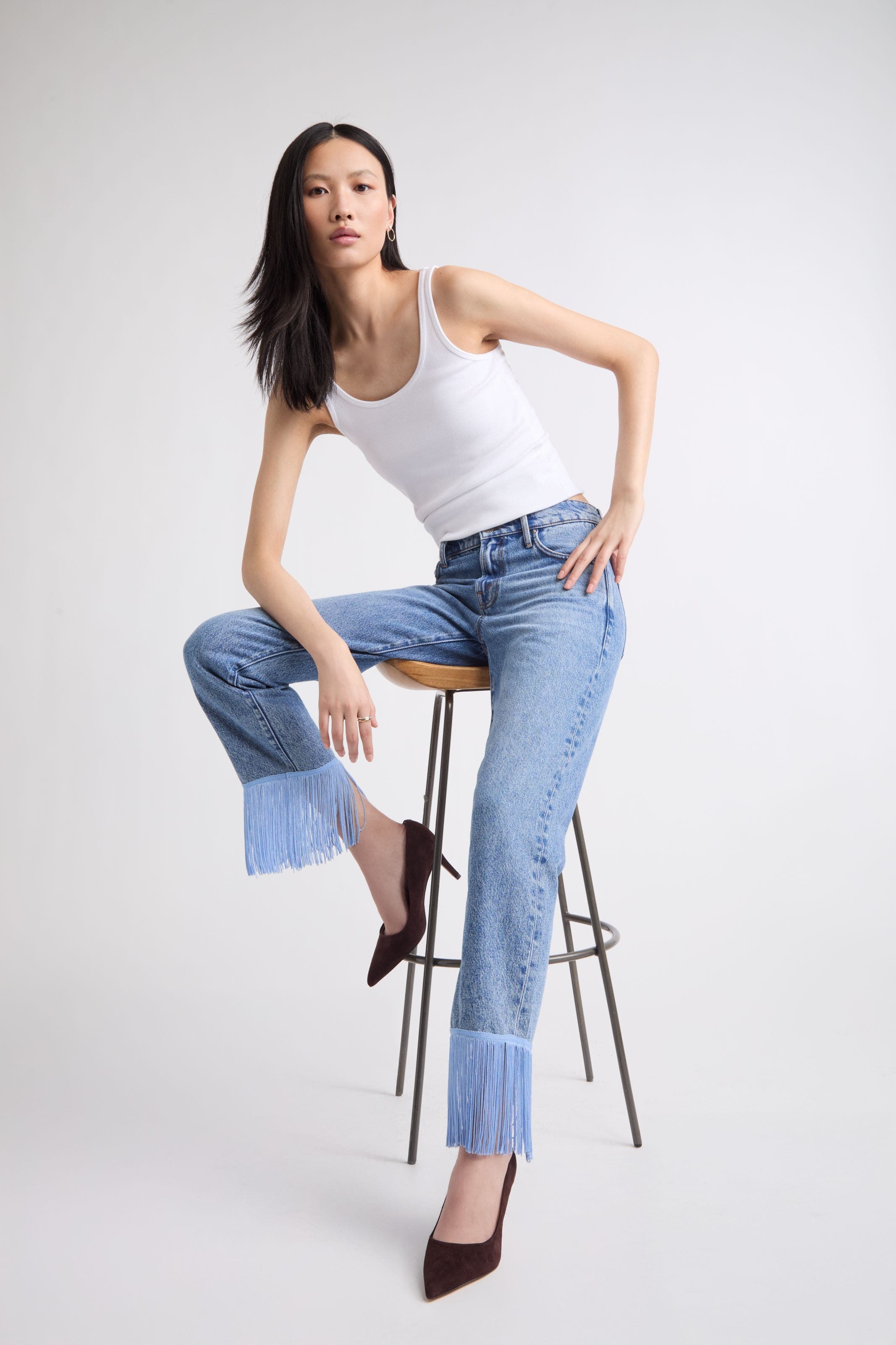 A woman wearing embellished fringe hemmed denim.