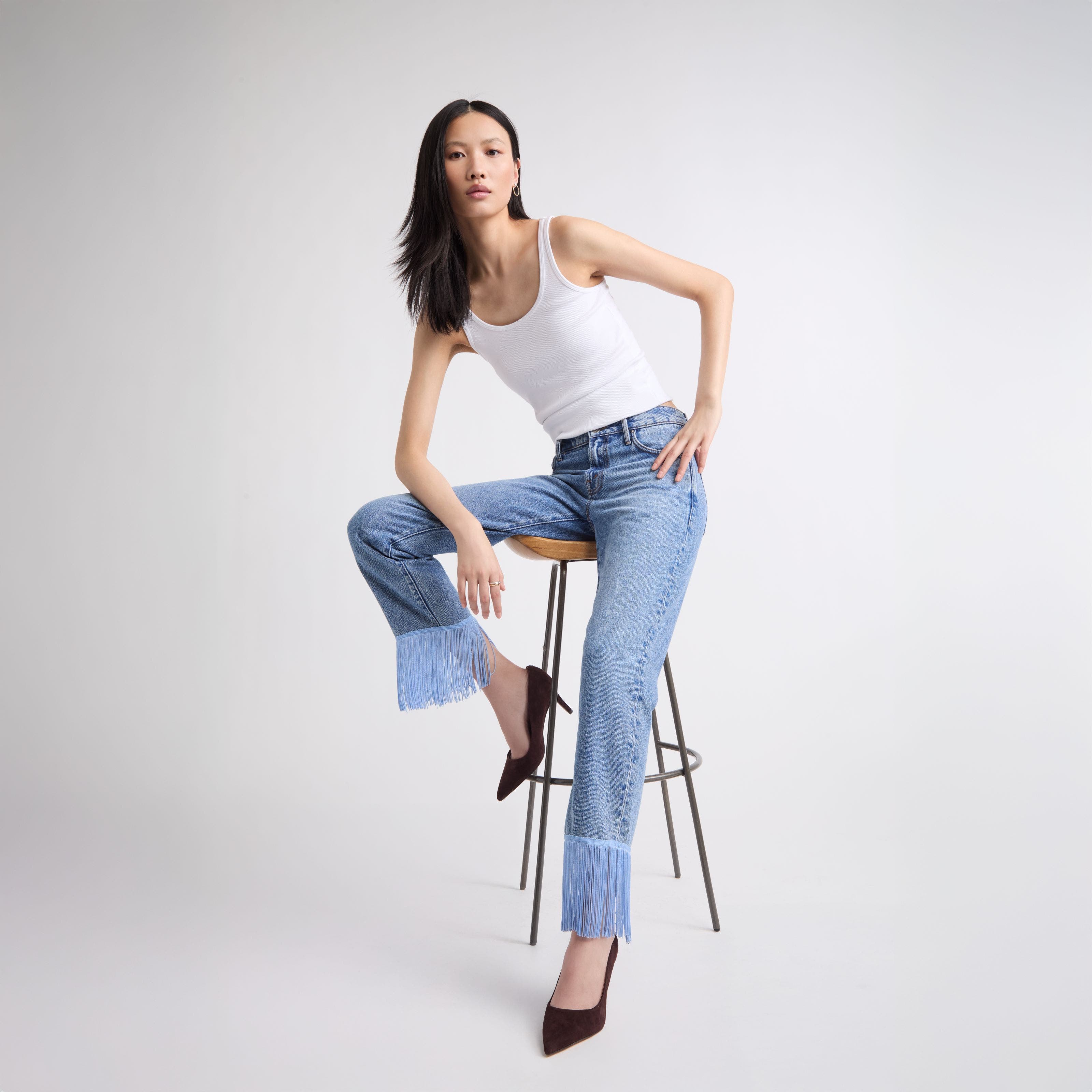 A woman wearing embellished fringe hemmed denim.