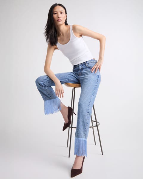 A woman wearing embellished fringe hemmed denim.