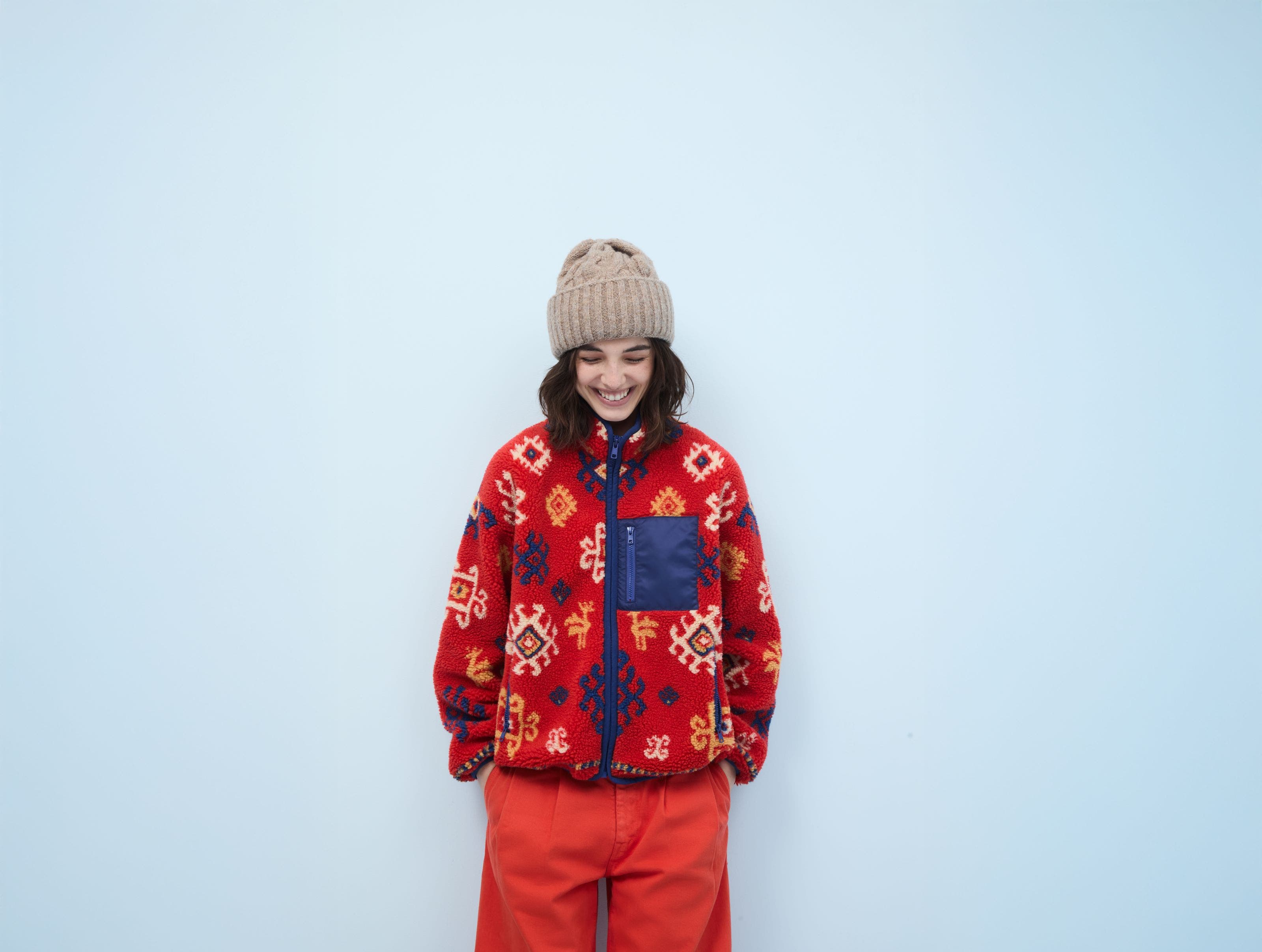 Woman wearing a fleece jacket, pants and beanie.