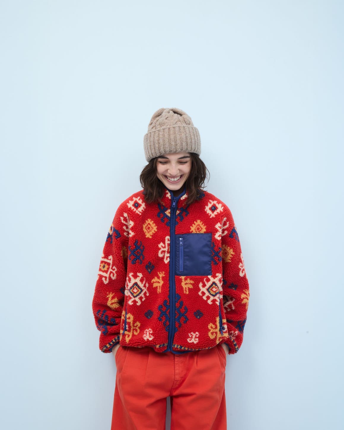 Woman wearing a fleece jacket, pants and beanie.