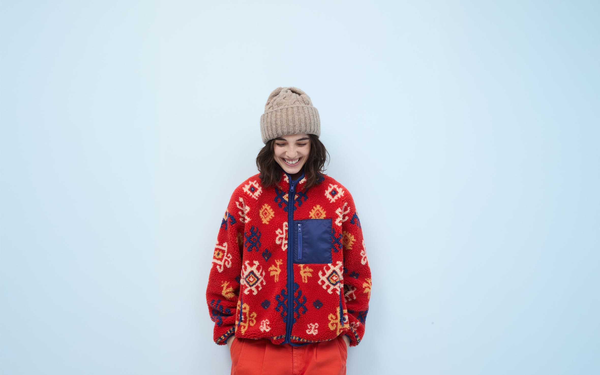 Woman wearing a fleece jacket, pants and beanie.