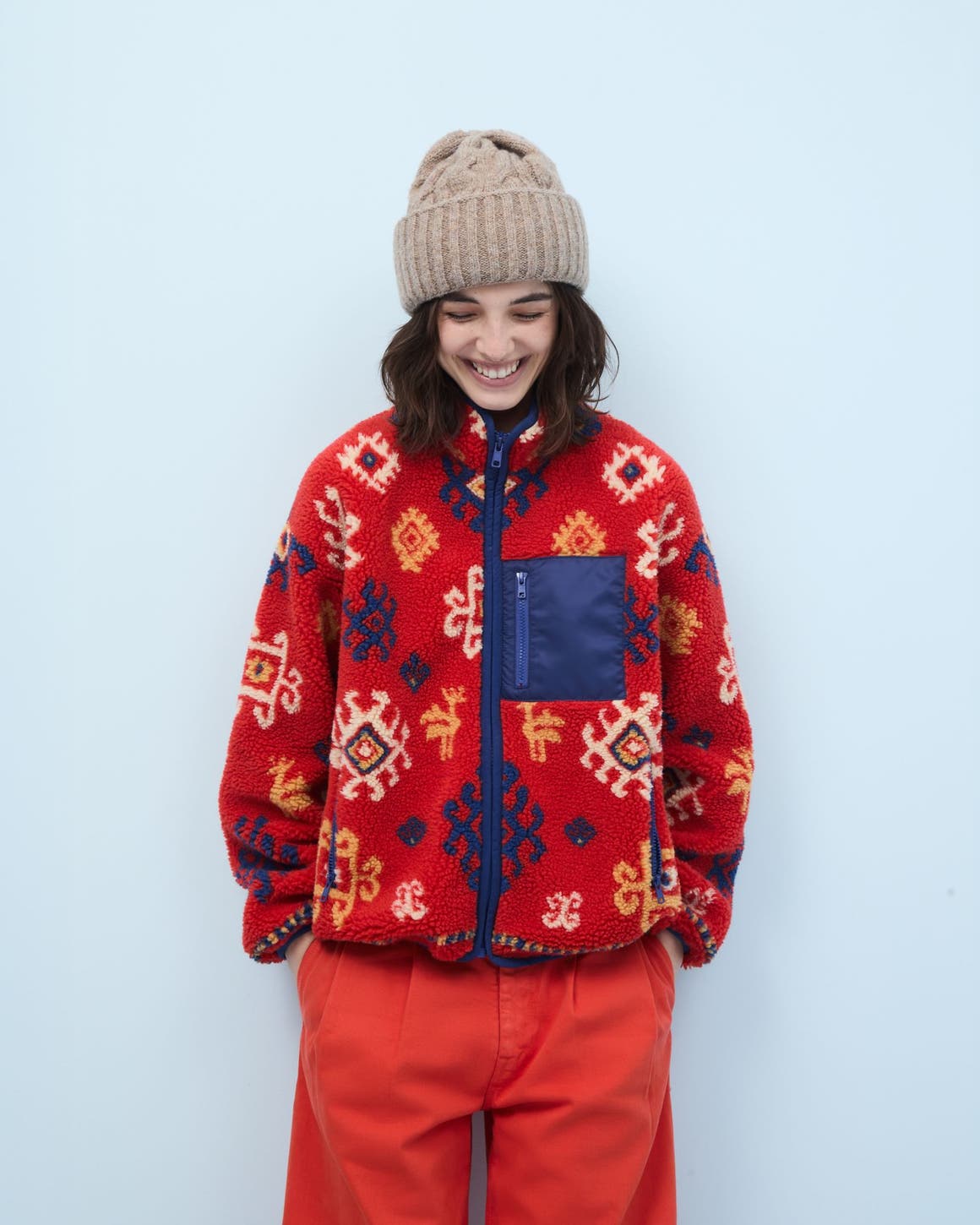 Woman wearing a fleece jacket, pants and beanie.