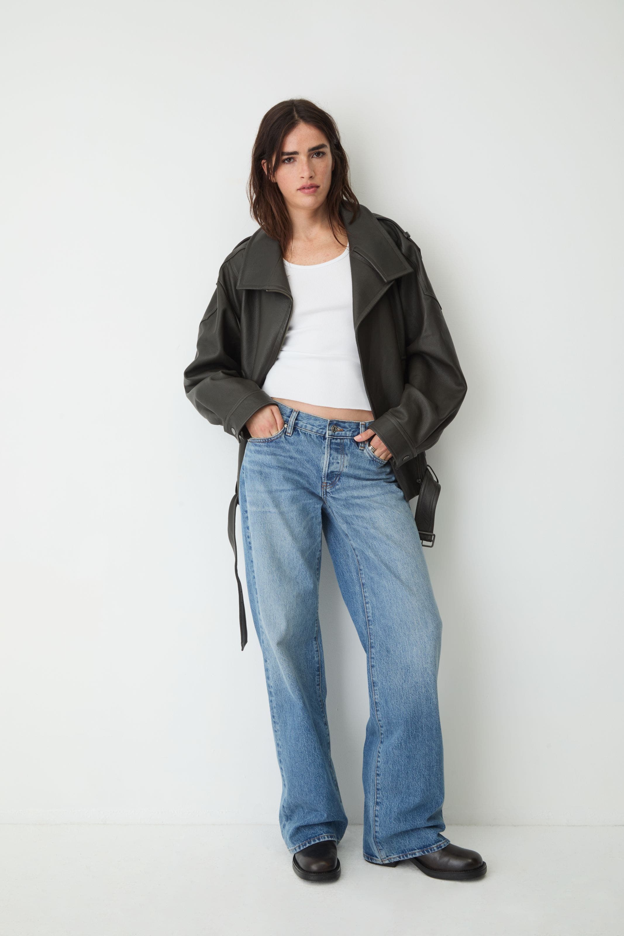 Woman in leather jacket and wide jeans